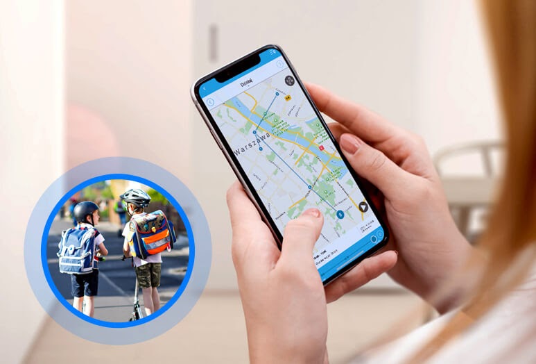 Funkcja lokalizacji w telefonie na rękę GJD.06, czyli kobieta trzymająca w dłoniach telefon z aplikacją Gdzie Jest Dziecko, na której widać mapę z zaznaczonymi miejscami, w których przebywał bliski oraz miniatura przedstawiająca dwóch chłopców jadących w ciepły dzień z kaskami i plecakami szkolnymi na hulajnogach